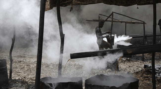 A man works at an illegal oil refinery site
